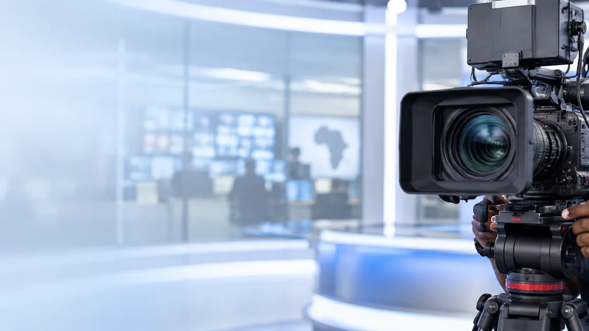 Television camera operator in a modern broadcast studio